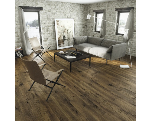 Wohnzimmer mit Holzboden, Sofa und Sesseln vor einer Steinwand