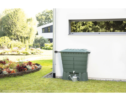 Regentonne im Garten mit Blumenecke und Hauswand