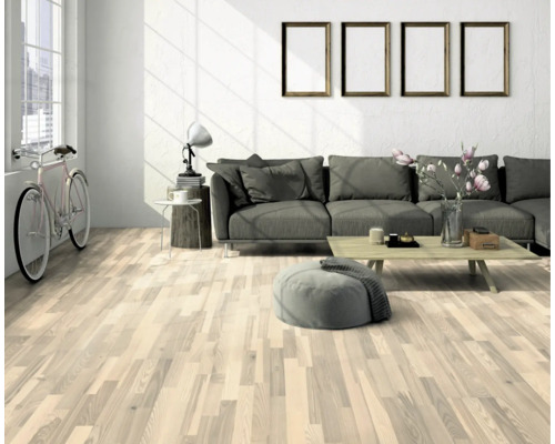 Heller Wohnraum mit Holzboden, Sofa und dekorativen Elementen für ein wohnliches Ambiente.