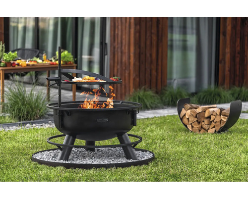 Feuerstelle mit Grillrost und Holzkorb auf Rasen