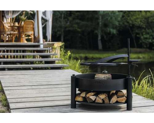 Grillstelle mit Holzablage auf einer Holzterrasse in der Nähe eines Teiches.