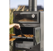 Ein Mann schiebt eine Mahlzeit mit einem Spatel in einen Outdoor-Ofen der Marke Cook King.