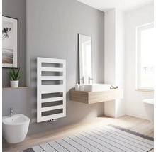 Helles Badezimmer mit weißem Heizkörper, Waschtisch, Spiegel und Bidet.