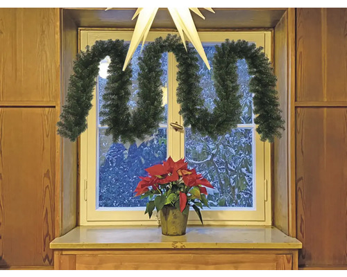 Dekorierte Fensterbank mit Tannengirlande und Weihnachtsstern