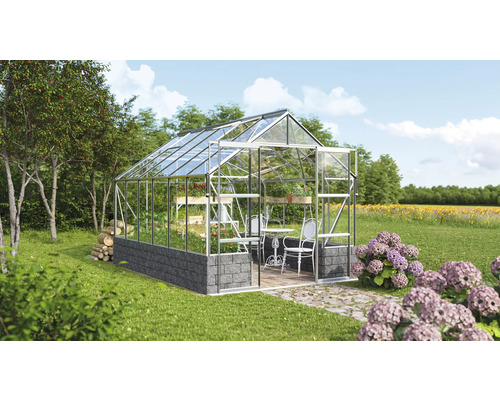 Gewächshaus mit Regalen, Tisch und Stühlen im Garten