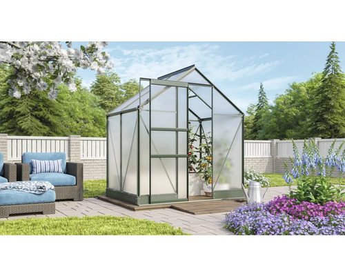 Gewächshaus im Garten mit Pflanzen und Gartenmöbeln