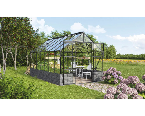 Gewächshaus im Garten mit Pflanzen und Gartenmöbeln.