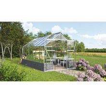 Gewächshaus aus Glas und Stein im Garten.