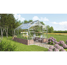 Gewächshaus mit Ziegelmauer und Glasstruktur im Garten