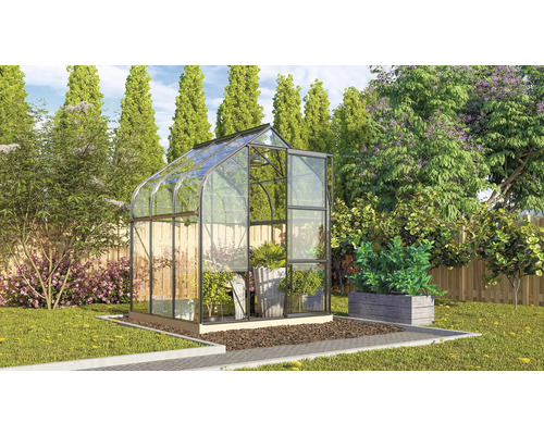 Gewächshaus aus Glas und Metall im Garten mit Pflanzen