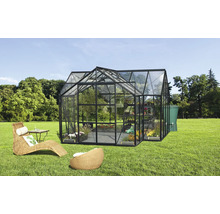 Gewächshaus mit Pflanzen, Möbeln und Wassertank im Garten