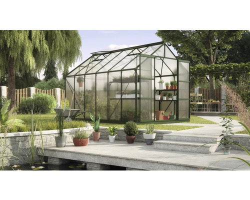 Gewächshaus im Garten mit Pflanzen und Gartengeräten