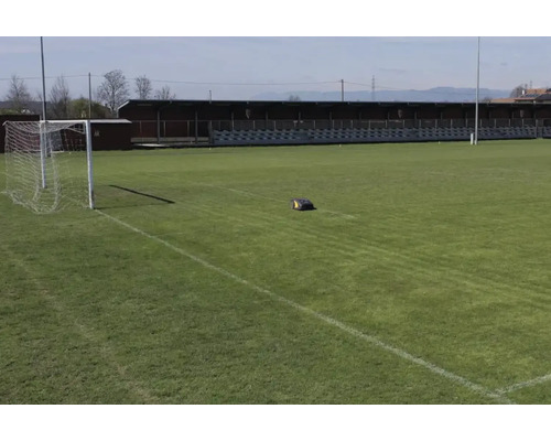 Rasenmäherroboter auf einem Fußballfeld mit Tor