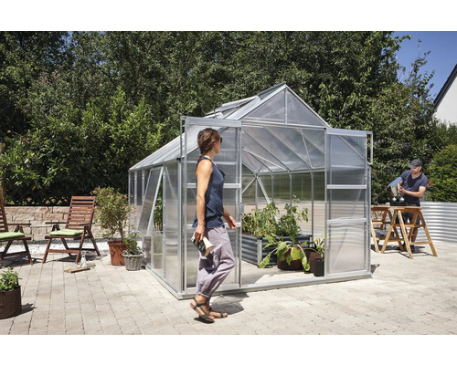 Gewächshaus mit Pflanzen im Garten und zwei Personen