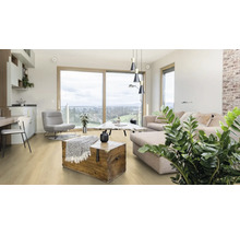 Heller Wohnraum mit Sofa, Sessel, Holztruhe und Holzboden