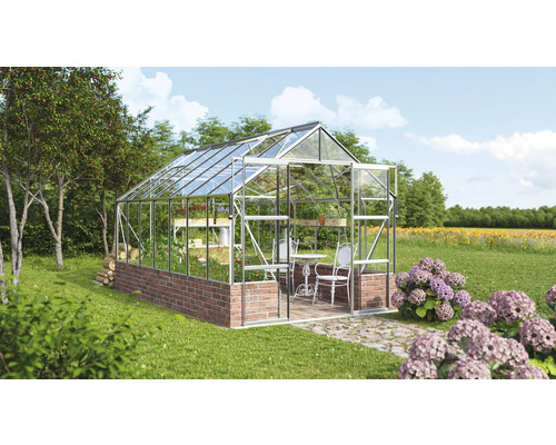 Gewächshaus mit Regalen, Tisch und Stühlen im Garten