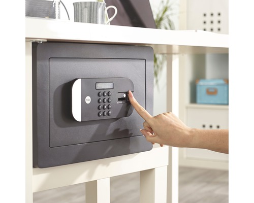 Ein Tresor mit Fingerabdruckscanner wird mit einem Finger bedient.