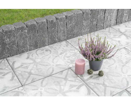 Gestaltungsidee für Terrasse mit Pflastersteinen, Rasenkantensteinen, Heidekraut und Kerze