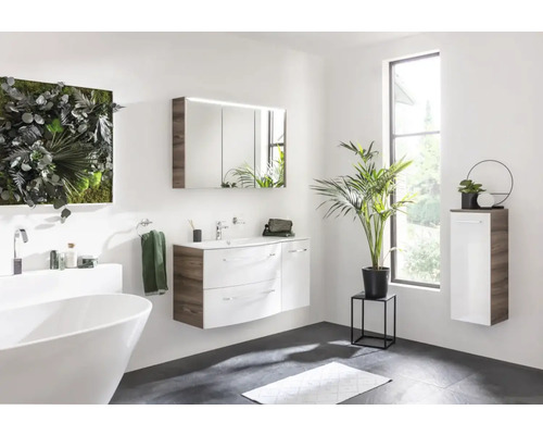 Helles Badezimmer mit Badewanne, Waschtisch, Spiegelschrank und Grünpflanzen für eine freundliche Atmosphäre