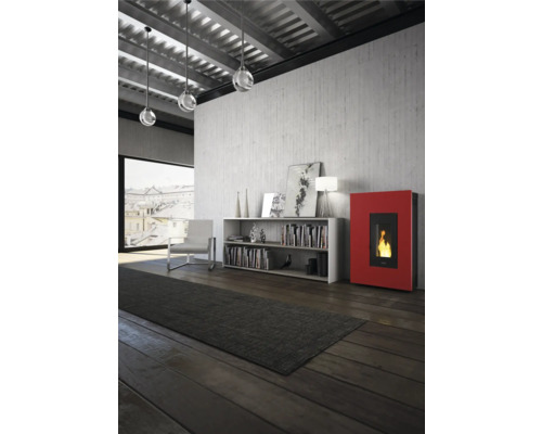 Wohnzimmer mit Pelletöfen, Bücherregal, Sessel, Teppich und Pendelleuchten unter einer Decke.