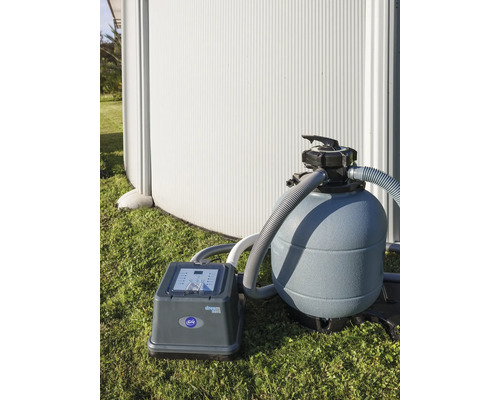 Sandfilteranlage neben einem Schwimmbecken auf Gras