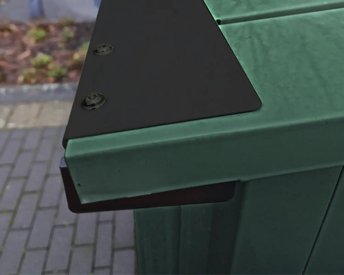 Detailansicht einer grünen Mülltonnenbox mit schwarzer Abdeckung und Schrauben