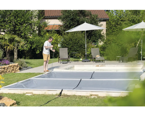 Abgedecktes Schwimmbecken im Garten mit Person bei der Handhabung