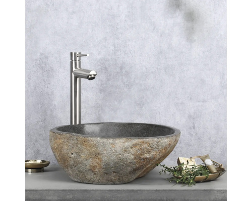 Steinwaschbecken mit Armatur und Badaccessoires auf einer Arbeitsplatte
