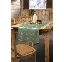 Festlich gedeckter Holztisch mit Tischläufer, Laterne, Tannenzapfen und Nüssen für die Weihnachtszeit.