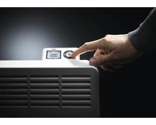 Nahaufnahme eines Heizgerätes mit einer Hand, die die Temperatur auf dem Display einstellt