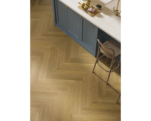 Verlegung von Holzimitatfliesen im Fischgrätmuster in einem Küchenbereich.