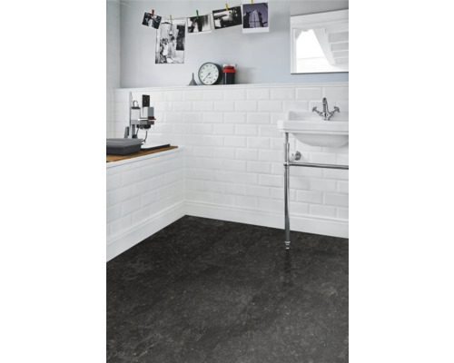 Badezimmer mit weißen Metrofliesen an der Wand und dunklem Boden.