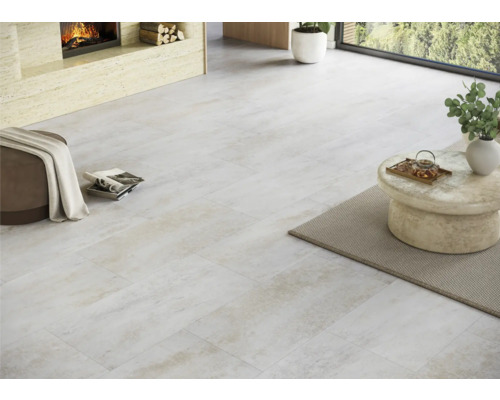 Heller Raum mit verlegten Bodenfliesen, Kamin und Sitzgelegenheit