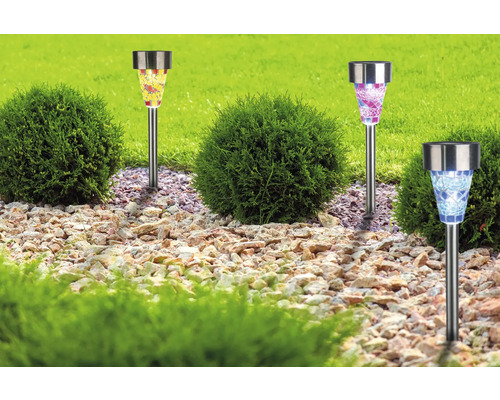 Dekorative Solarleuchten im Garten zwischen Büschen und Steinen.