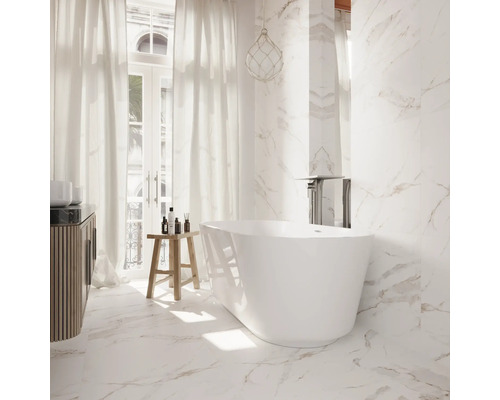 Helles Badezimmer mit freistehender Badewanne, Waschtisch und Marmorfliesen