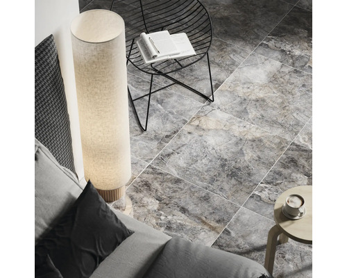 Innenraumansicht mit Bodenfliesen in Marmoroptik, Stehleuchte und Sitzgelegenheit