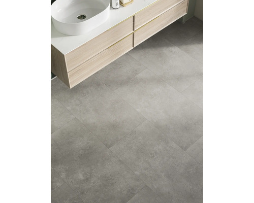 Badezimmer mit Waschbecken auf Waschtisch und grauen Bodenfliesen.