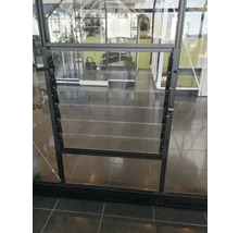 Detailansicht eines Gewächshauses mit einem Fenster mit Lamellen