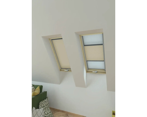 Zwei Dachfenster mit Sichtschutzrollos in einem hellen Raum.