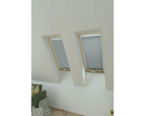 Zwei Dachfenster mit Jalousien in einem hellen Raum.