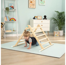 Kind klettert auf einem hölzernen Klettergerüst in einem hellen Kinderzimmer.