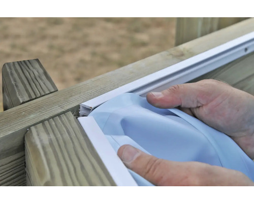 Person installiert eine Abdeckung auf einer Holzkonstruktion.