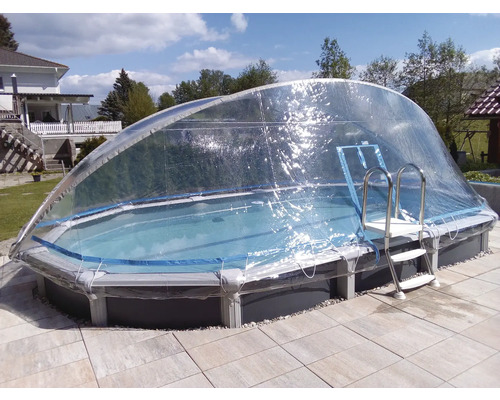 Schwimmbecken mit transparenter Überdachung und Leiter im Garten