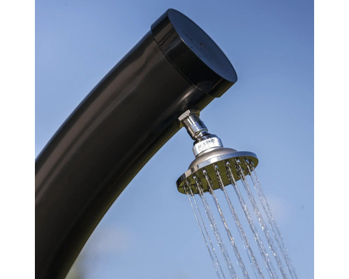 Außendusche mit Wasserstrahl vor blauem Himmel