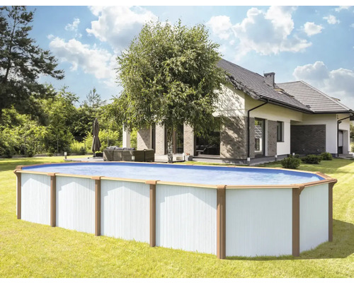 Ovaler Swimmingpool im Garten mit Haus im Hintergrund.