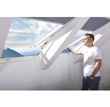 Dachfenster mit Mann, der es öffnet und Blick auf die Berge