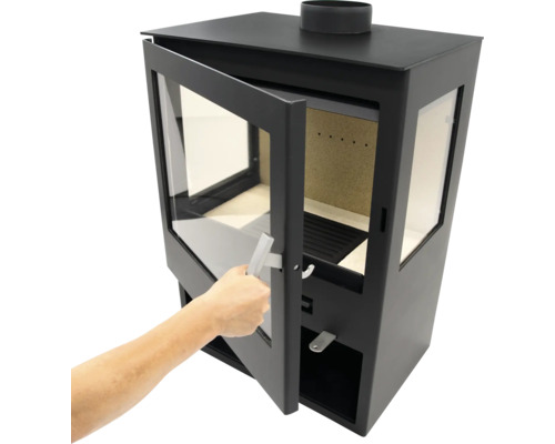 Ofen mit Brennraum und Tür, die von einer Hand geöffnet wird.