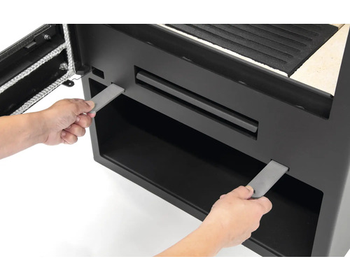 Detailansicht eines Kaminofens beim Einsetzen von Metallstreifen zur Montage.