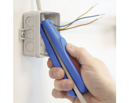 Eine Hand verwendet eine Abisolierzange an einem Elektrokabel in einer Verteilerdose