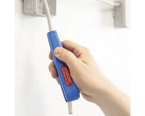 Hand hält einen blauen Abisolierer zum Entfernen der Isolierung von einem Kabel